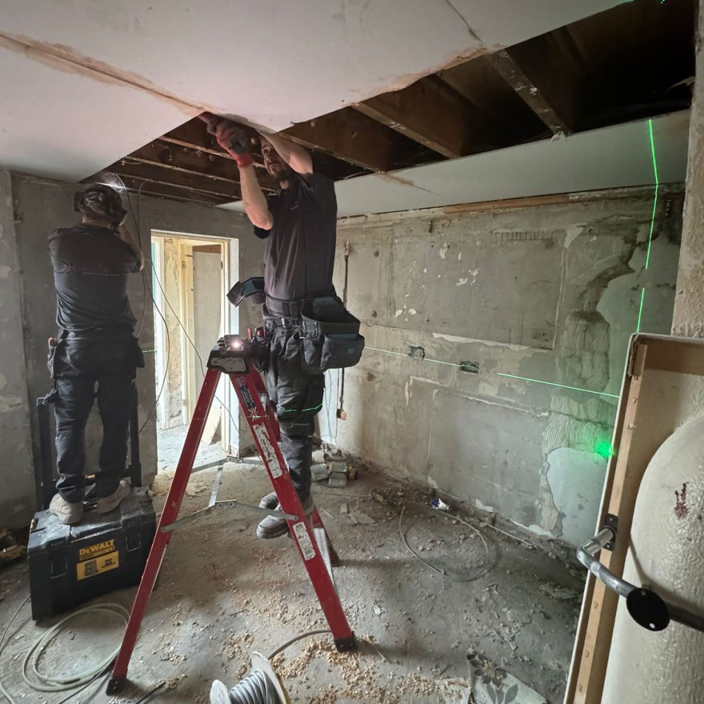 Hollis electrician working inside of HMO property.