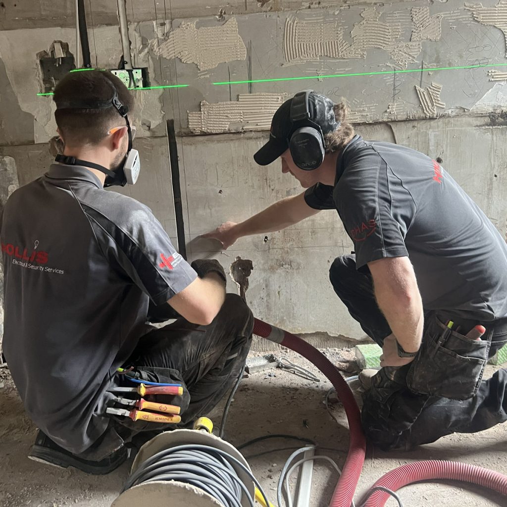 Hollis Electrical team inside of a Void Property installing electrics using specialist tools.