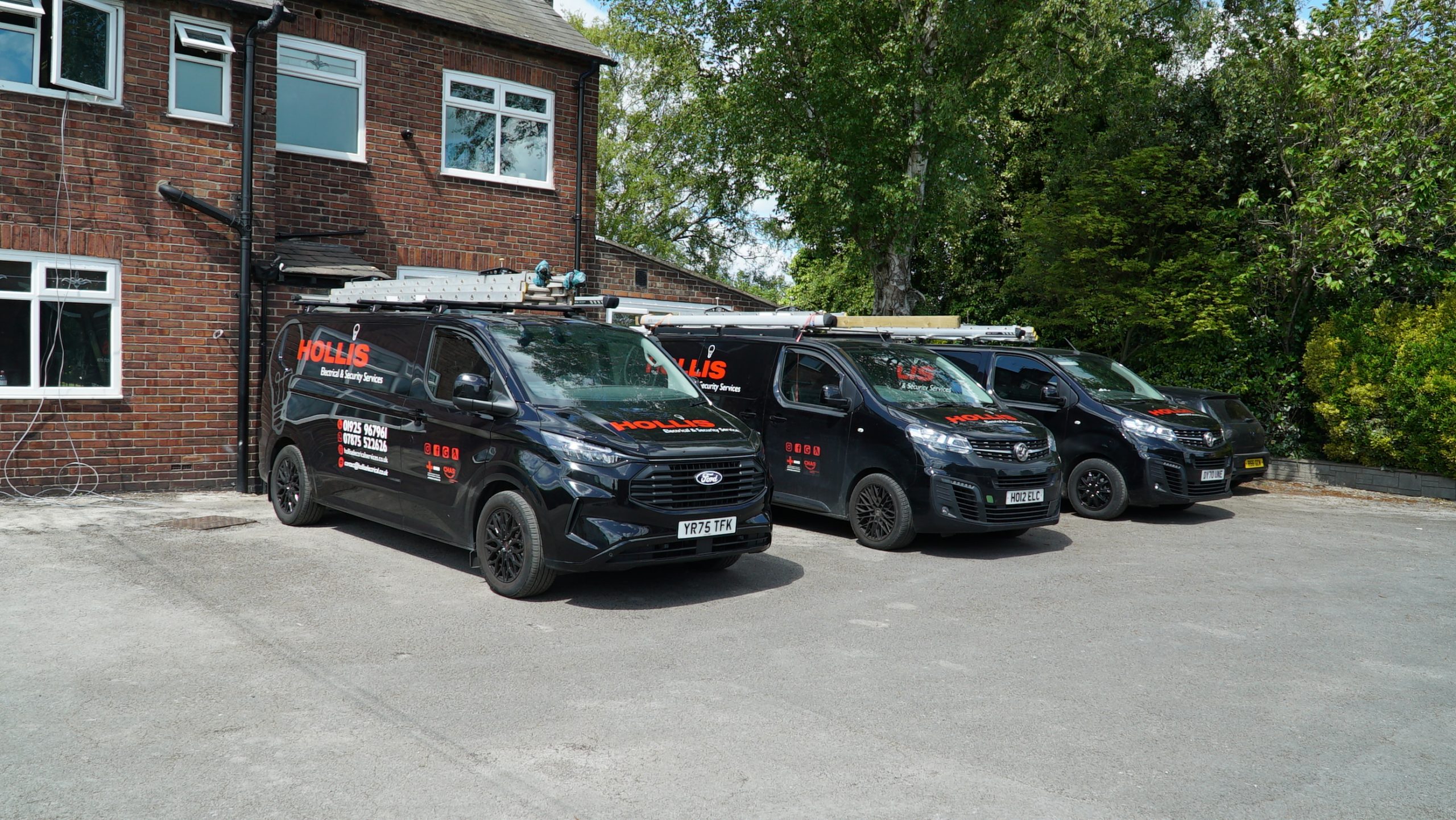 Hollis Electrical vans outside a property